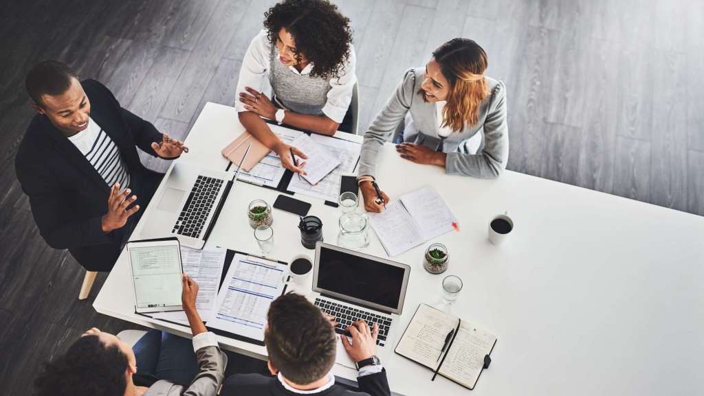 “Church leadership team meeting around a table planning upcoming events and marketing timelines.”