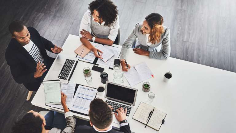 “Church leadership team meeting around a table planning upcoming events and marketing timelines.”