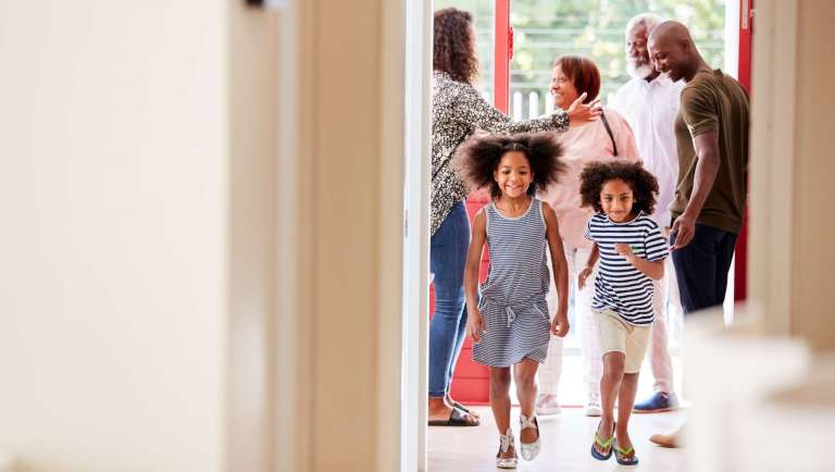 Smiling family arriving together at church for Back-to-Church Sunday
