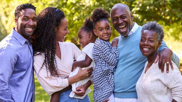 Multi-generational African American family smiling outdoors, symbolizing how household decisions shape where families choose to worship.