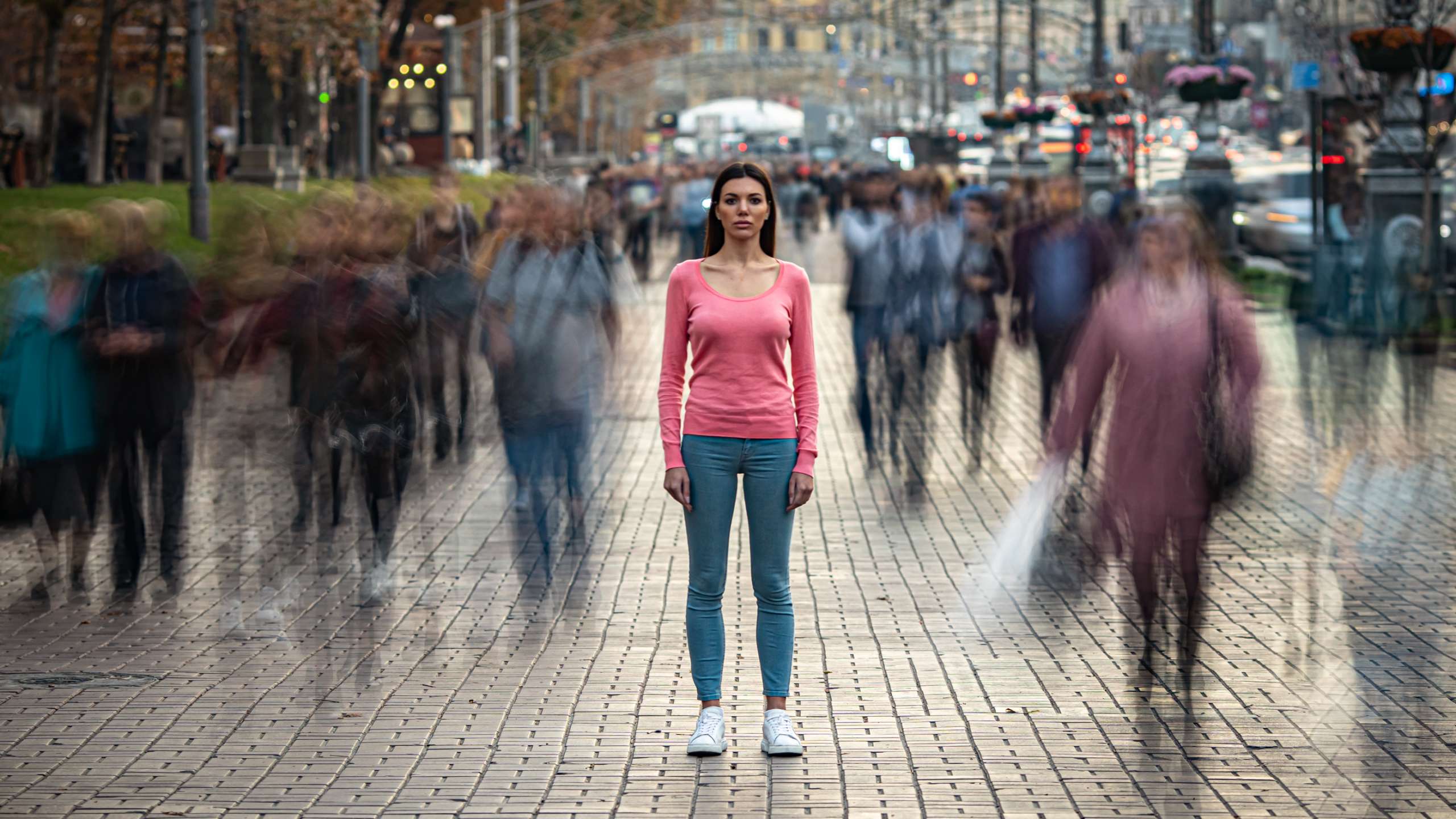 Woman standing still in a fast-moving crowd, representing the importance of identifying and connecting with your target audience.