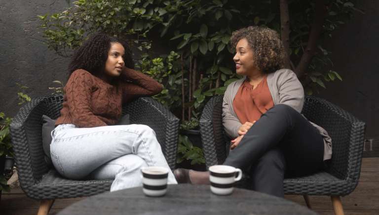Two women talking over coffee in a warm, natural setting, symbolizing connection, empathy, and relational ministry like Jesus.