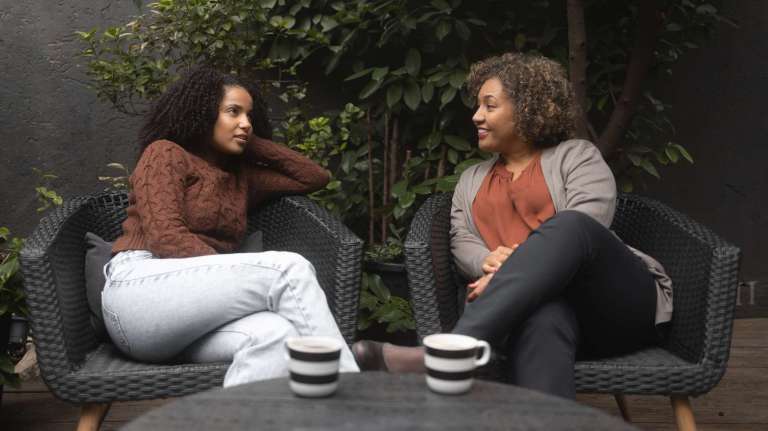 Two women talking over coffee in a warm, natural setting, symbolizing connection, empathy, and relational ministry like Jesus.